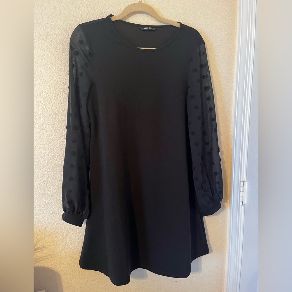 A black dress with see through sleeves.